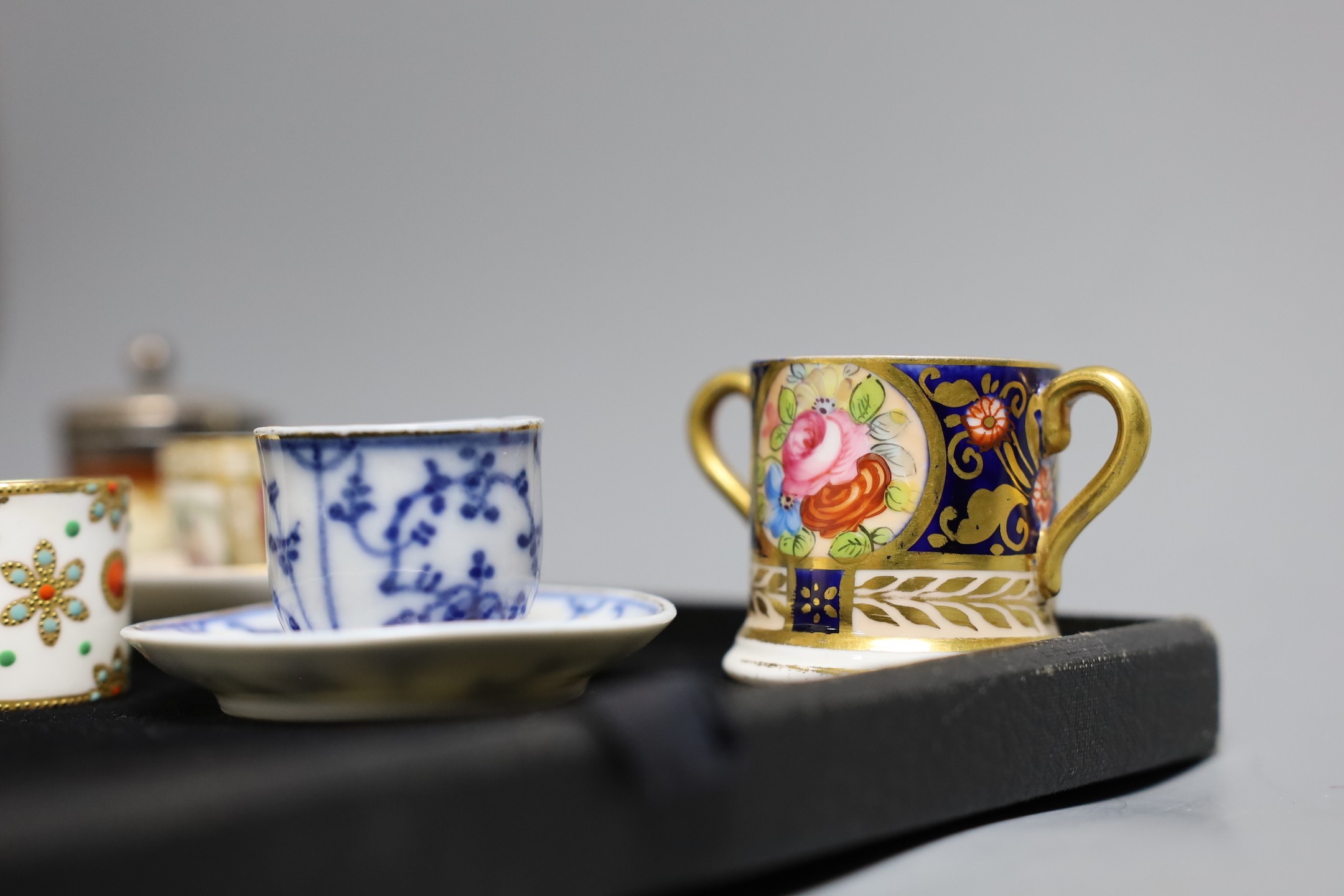 Miniatures: A Spode type Hydra jug and basin painted with flowers, a Crown Staffordshire two handled mug with flowers on a gilded blue ground, two continental cups and saucer one with Watteauesque scenes, the other in bl